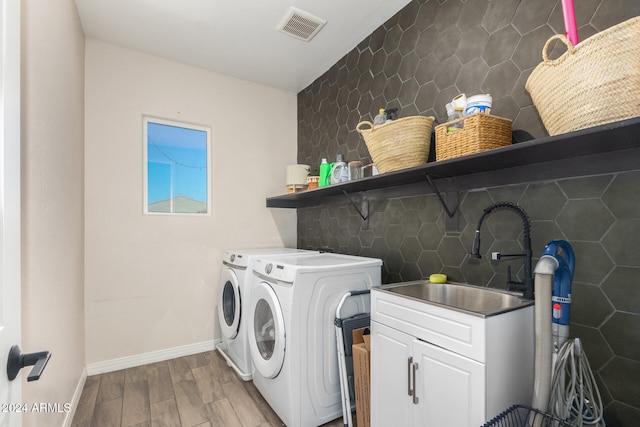 washroom featuring light hardwood / wood-style floors, independent washer and dryer, and sink