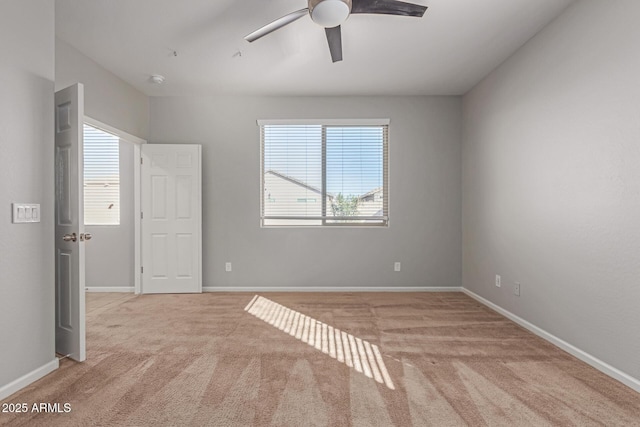 spare room with light carpet, ceiling fan, and a healthy amount of sunlight