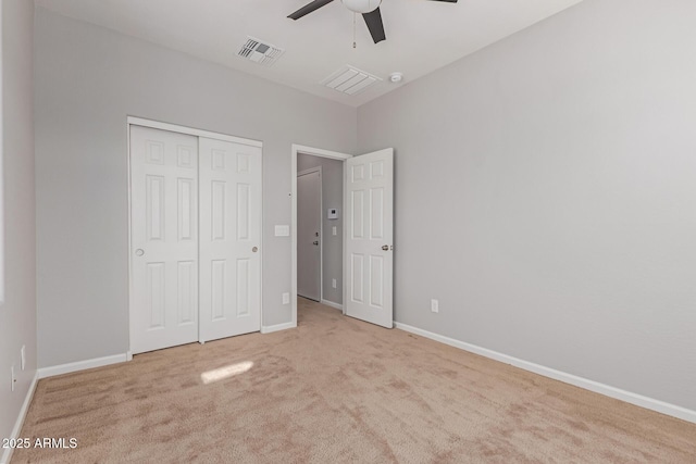 unfurnished bedroom with light colored carpet, a closet, and ceiling fan