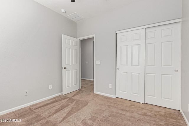 unfurnished bedroom featuring light carpet and a closet