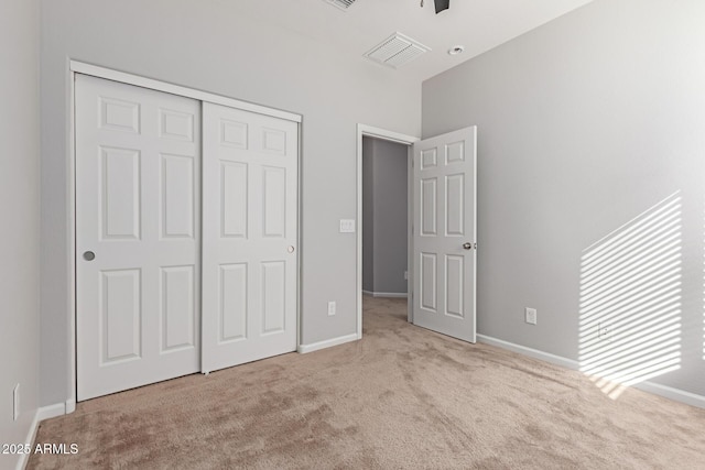 unfurnished bedroom with light carpet and a closet