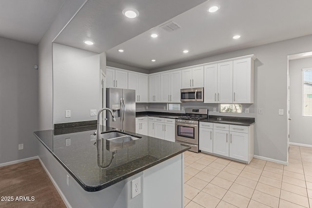 kitchen with white cabinetry, sink, kitchen peninsula, and appliances with stainless steel finishes