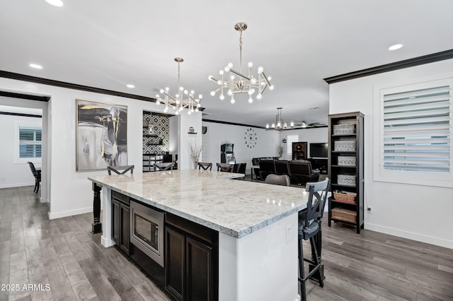 5223 S Axiom, Mesa, AZ 85212 - kitchen with stainless steel microwave, a chandelier, crown molding, a kitchen breakfast bar, and baseboards