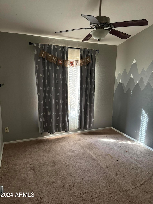 carpeted spare room with ceiling fan