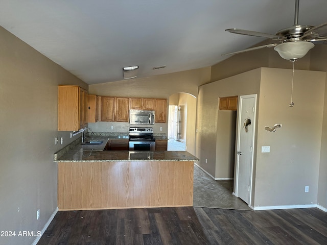 kitchen featuring kitchen peninsula, appliances with stainless steel finishes, dark wood-type flooring, sink, and lofted ceiling