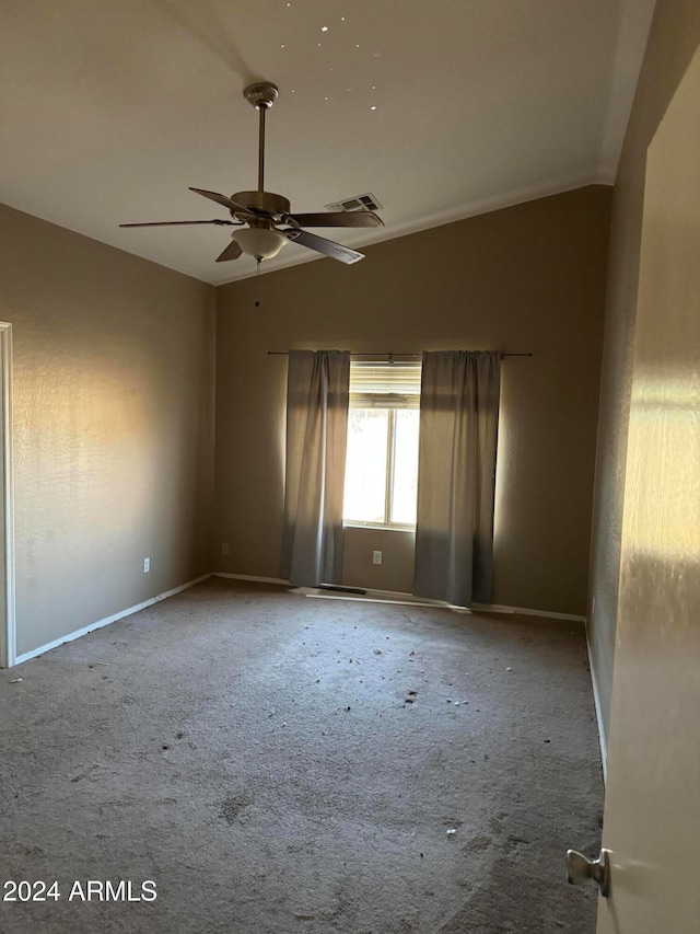 spare room featuring carpet flooring, vaulted ceiling, and ceiling fan