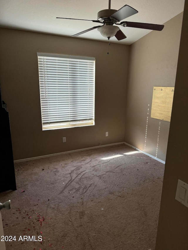 carpeted spare room with ceiling fan