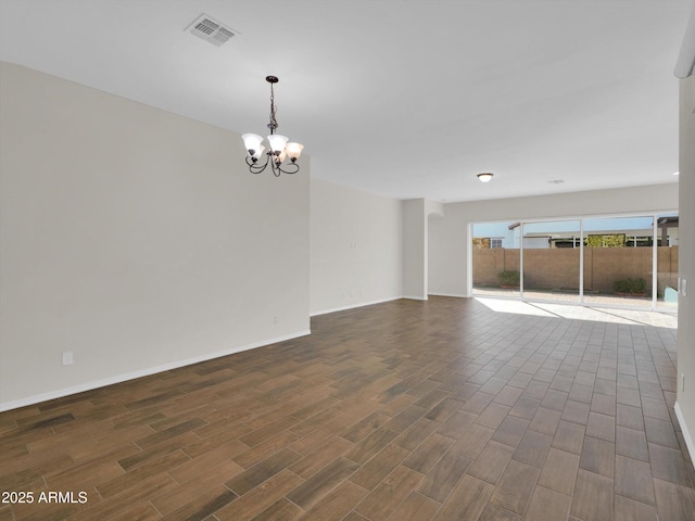 unfurnished room featuring an inviting chandelier