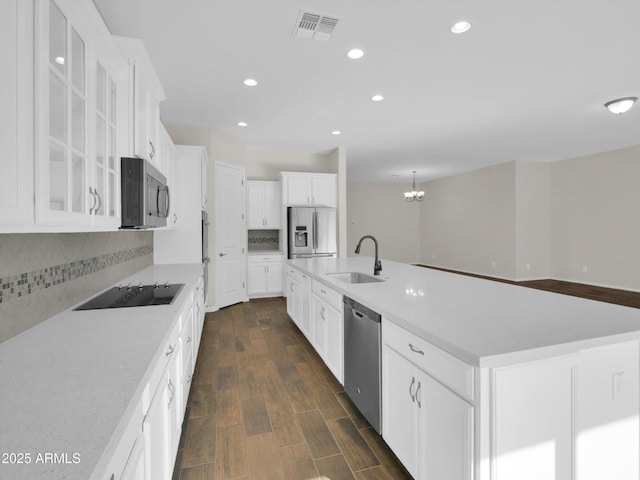 kitchen featuring sink, white cabinetry, backsplash, stainless steel appliances, and a spacious island