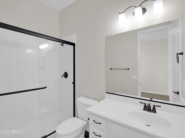 bathroom with vanity, a shower with door, and toilet