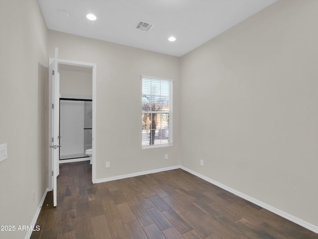 unfurnished bedroom featuring a walk in closet and dark wood-type flooring