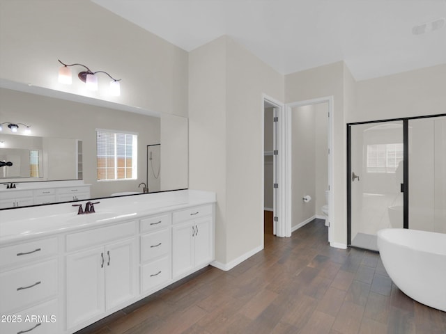 full bathroom with wood-type flooring, toilet, independent shower and bath, and vanity