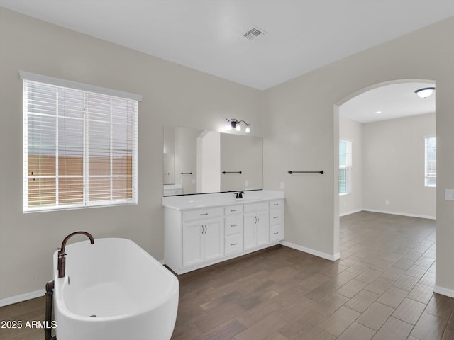 bathroom featuring vanity and a bath