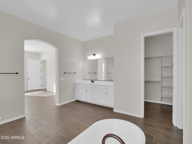 bathroom featuring built in shelves, vanity, and a bathing tub