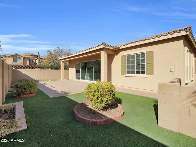 back of property featuring a yard and a patio area