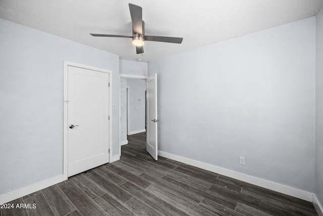 unfurnished bedroom featuring ceiling fan and dark hardwood / wood-style flooring