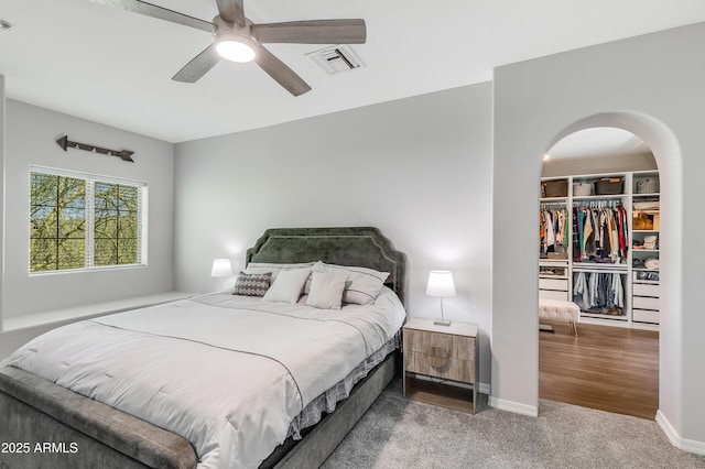 3935 E Rough Rider Rd Unit 1039, Phoenix, AZ 85050 - carpeted bedroom with arched walkways, a walk in closet, a closet, ceiling fan, and baseboards