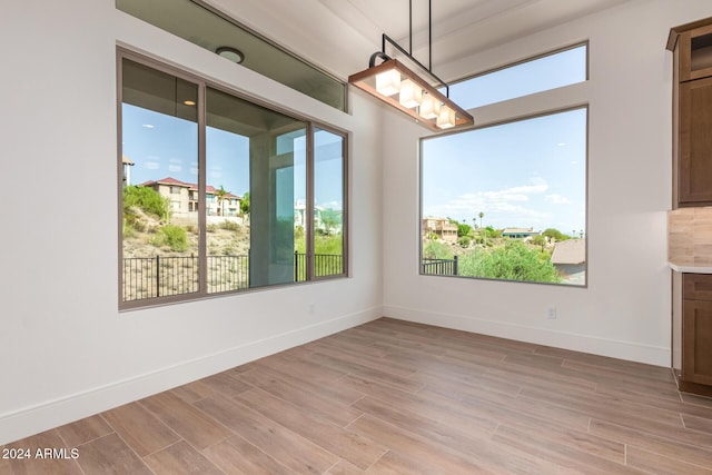 15522 E Chicory Dr, Fountain Hills, AZ 85268 - unfurnished dining area with a chandelier, light wood-style flooring, and baseboards