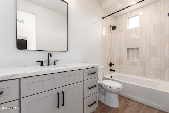 full bathroom with vanity, tiled shower / bath combo, and toilet