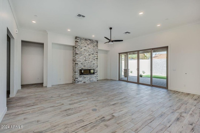 unfurnished living room featuring light hardwood / wood-style floors, a stone fireplace, ceiling fan, and ornamental molding