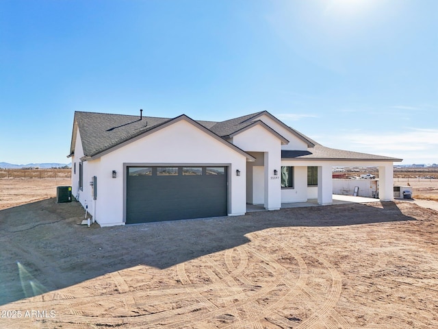 view of front of home featuring cooling unit and a garage