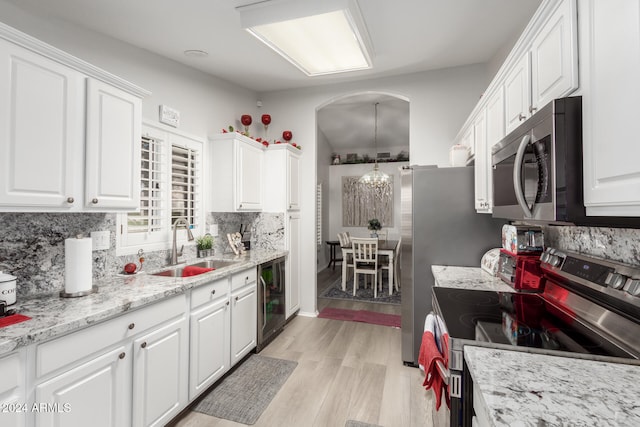 kitchen with white cabinetry, appliances with stainless steel finishes, decorative backsplash, and light hardwood / wood-style floors