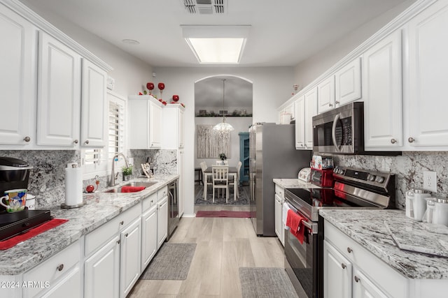 kitchen with white cabinetry, appliances with stainless steel finishes, light hardwood / wood-style floors, and sink