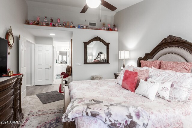 bedroom featuring ceiling fan, connected bathroom, and light hardwood / wood-style flooring