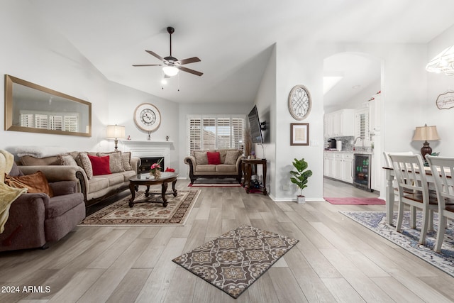 living room with wine cooler, light wood-type flooring, vaulted ceiling, and ceiling fan