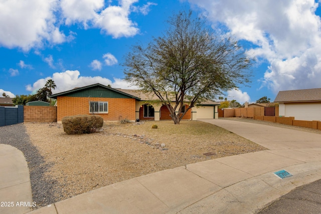 single story home featuring driveway, a garage, fence, and brick siding