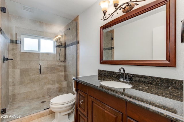 bathroom with a shower stall, toilet, and vanity