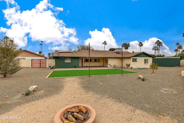 back of property featuring a gate, fence, and a patio