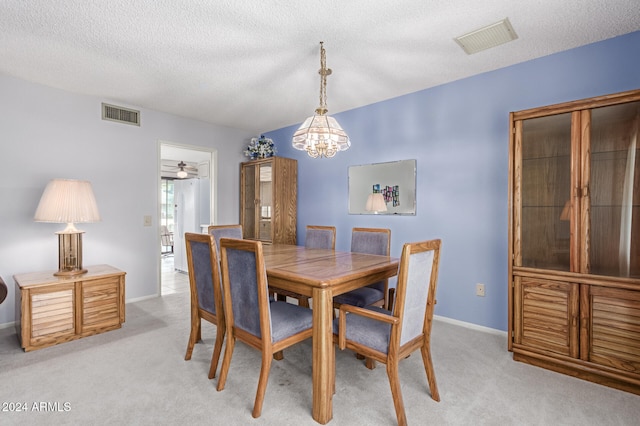 dining room featuring ceiling fan with notable chandelier, a textured ceiling, and light colored carpet