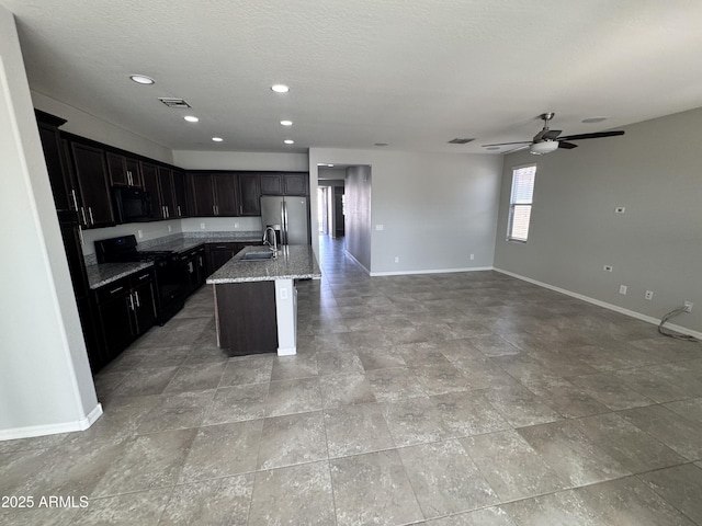 kitchen with stainless steel fridge with ice dispenser, sink, light stone counters, black range with electric cooktop, and a center island with sink