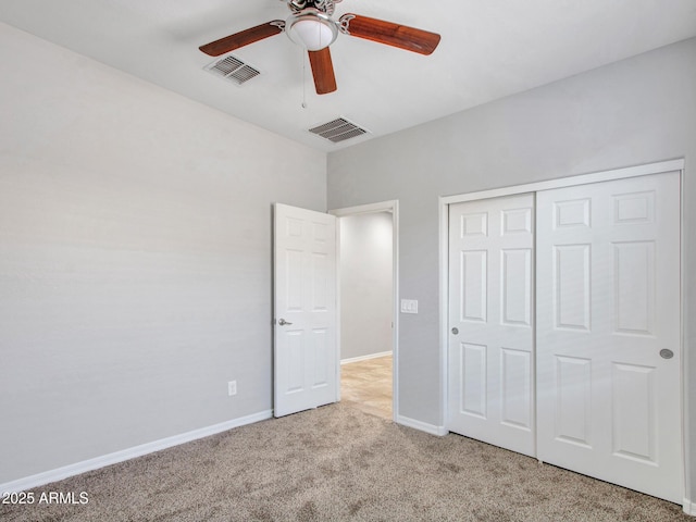 unfurnished bedroom with ceiling fan, light colored carpet, and a closet