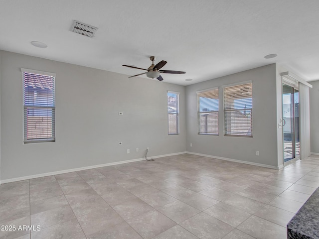 tiled empty room featuring ceiling fan