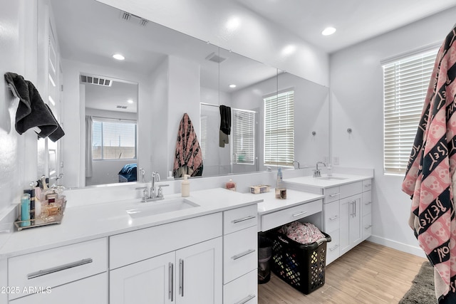 bathroom featuring walk in shower, wood-type flooring, and vanity