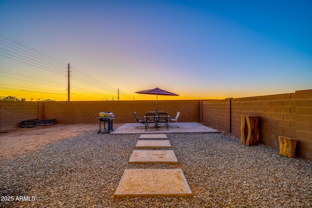 yard at dusk featuring a patio area