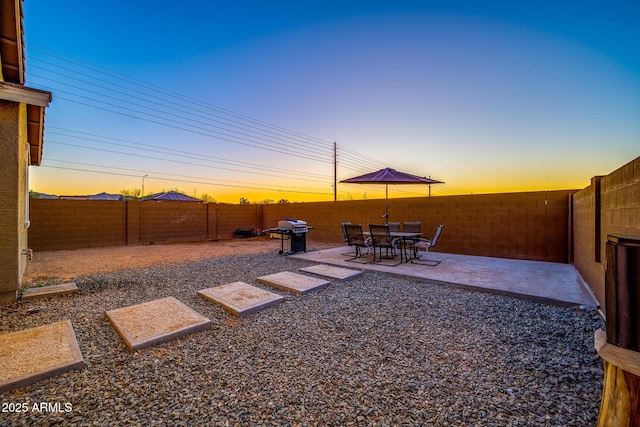 yard at dusk featuring a patio area