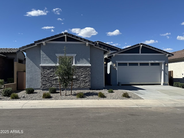 3260 W Caleb Rd, Phoenix, AZ 85083 - view of front of house with an attached garage, driveway, stone siding, and a tiled roof