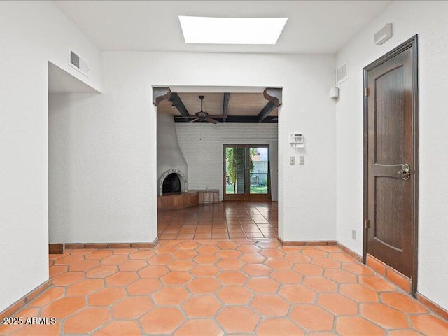7232 N 22 Nd St, Phoenix, AZ 85020 - unfurnished living room with beam ceiling, a skylight, a ceiling fan, baseboards, and a fireplace with raised hearth