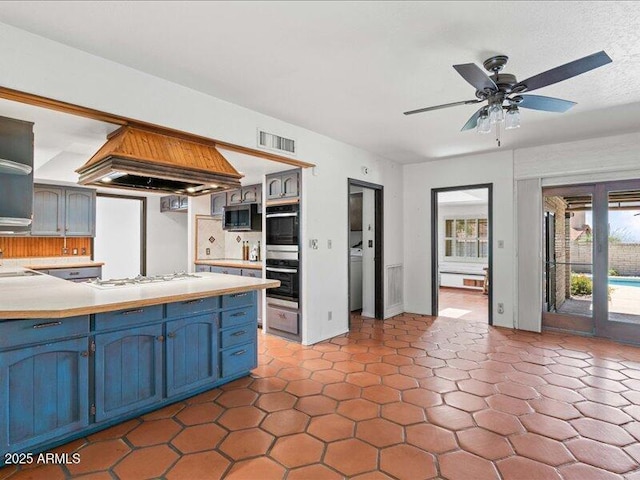 7232 N 22 Nd St, Phoenix, AZ 85020 - kitchen with stainless steel appliances, blue cabinetry, a peninsula, light countertops, and ceiling fan