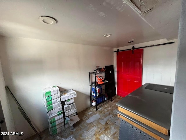 misc room featuring a barn door and dark tile floors