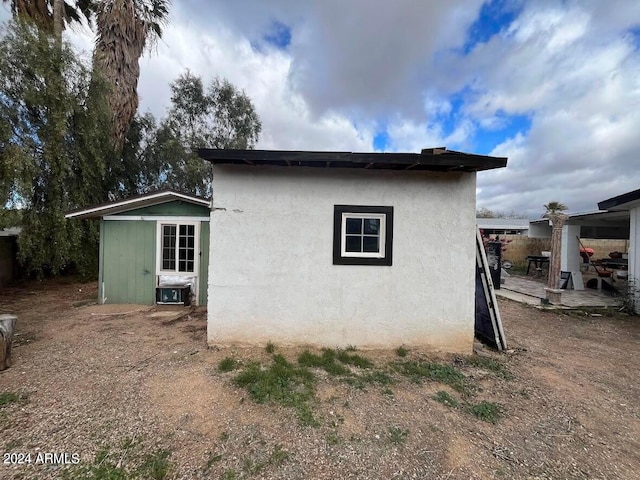 view of side of property with a patio area and an outdoor structure