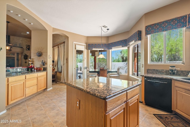 32826 N 54th St, Cave Creek, AZ 85331 - kitchen with black dishwasher, dark stone counters, a center island, light tile patterned floors, and arched walkways