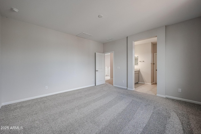 unfurnished bedroom featuring connected bathroom and light colored carpet