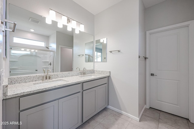 bathroom with tile patterned floors, vanity, and walk in shower