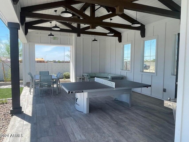 playroom with dark wood finished floors and vaulted ceiling with beams