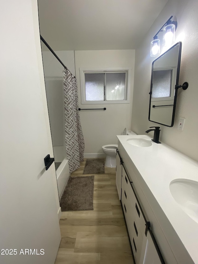 7201 N 16th Dr, Phoenix, AZ 85021 - full bathroom with double vanity, toilet, wood finished floors, shower / tub combo with curtain, and baseboards