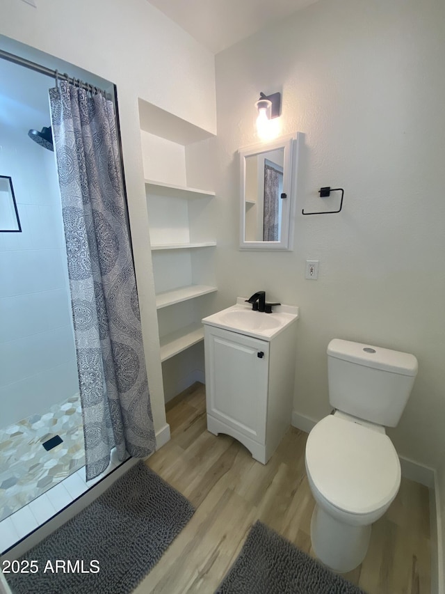 7201 N 16th Dr, Phoenix, AZ 85021 - full bathroom with wood finished floors, tiled shower, vanity, and toilet